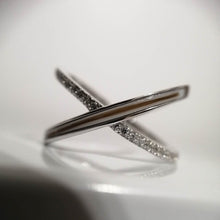 Load image into Gallery viewer, Un élégant bracelet Bague Crossover en argent avec des zircons étincelants couleur diamant, capturés sur un fond flou par MONA fine joaillerie.
