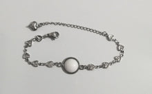 Load image into Gallery viewer, Un délicat bracelet Bijoux La Précieuse en acier inoxydable avec une pierre centrale blanche et des petites breloques en forme de cœur.
