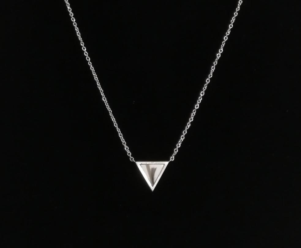 Un collier minimaliste en argent MONA joaillerie fine Triangle avec un pendentif triangulaire, présenté sur un fond sombre, créant un contraste saisissant.