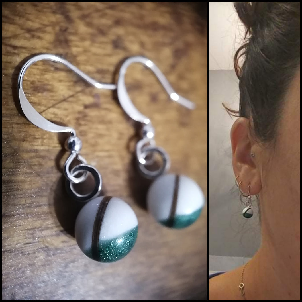 Un collage de deux images : à gauche, un gros plan d'une élégante paire de Boucles d'oreilles Pendantes avec crochets argentés et pendentifs sphériques présentant un motif vert et blanc scintillant de Bijoux La Précieuse.